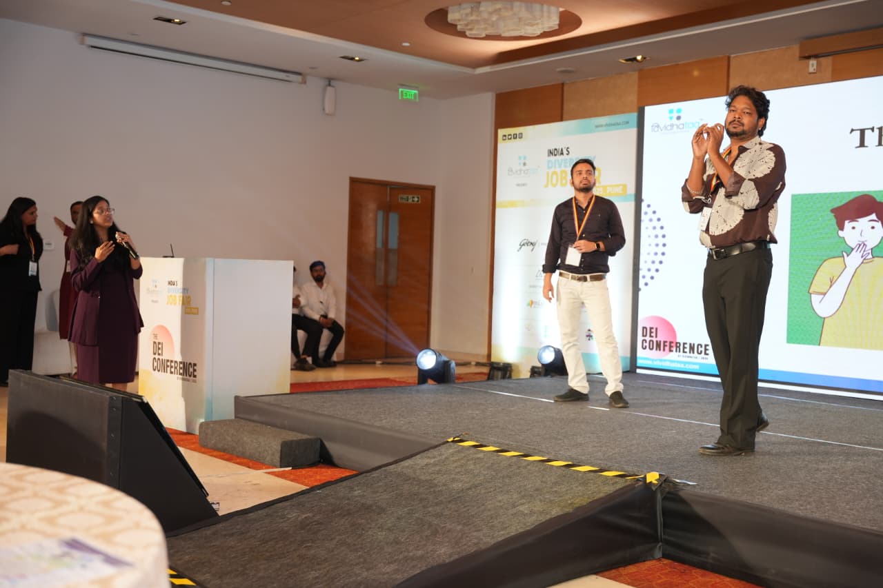 Tejal Patwari voice interpreting for a Deaf presenter on stage